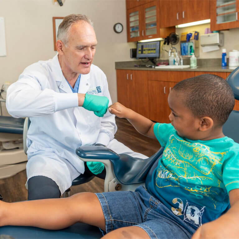 Dentist fist-bumping a small child