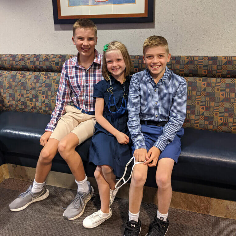 Three kids on a couch, smiling
